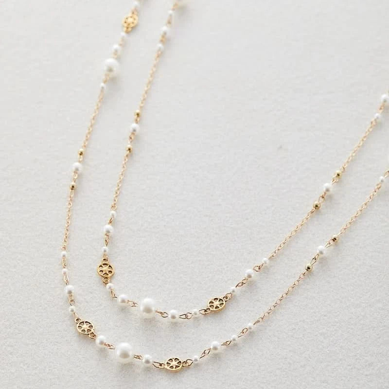 Layered pearl gold necklace worn on model