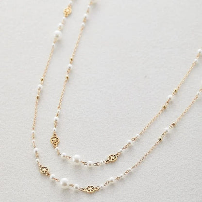 Layered pearl gold necklace worn on model